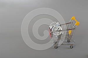 Alarm clock and shopping cart or trolley. Copy space for the text. Buying time concept