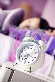 Alarm clock with a sleeping young woman