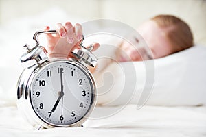 Alarm clock and sleeping young woman