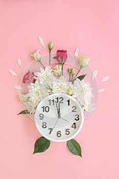 Alarm clock with small burgundy red roses, white peonies and petals