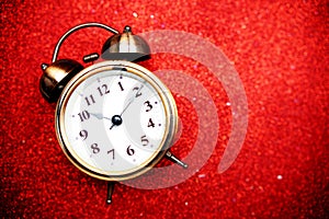 Alarm clock with space copy on red bokeh background