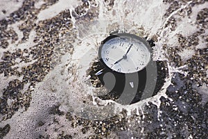 Alarm clock splashing in the beach water