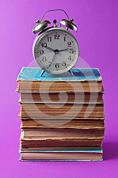 Alarm clock on stack book