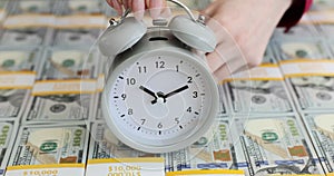 Alarm clock on stacks of dollar bills concept