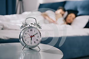 Alarm clock standing on table in bedroom at morning