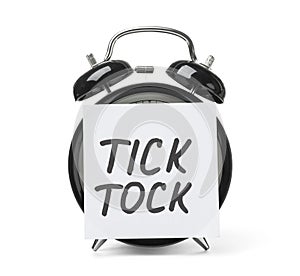 Alarm clock and sticky note with words TICK TOCK photo