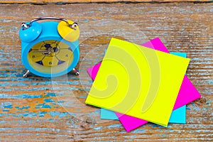 Alarm clock and a sticky notes with empty space for a text on