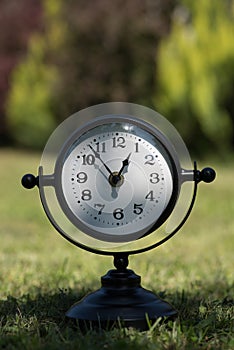 Alarm clock in sunlit spring garden