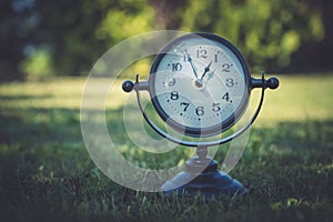 Alarm clock in sunlit spring garden