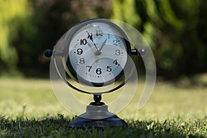 Alarm clock in sunlit spring garden