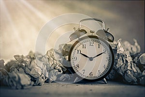 Alarm clock in a wastepaper photo