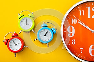 Alarm clock on yellow background