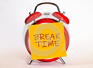 An alarm clock and a yellow note with text Break Time.