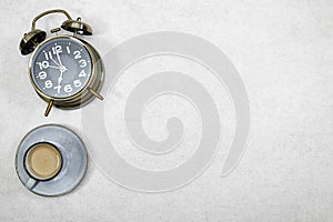 alarm o\'clock showing 7 o\'clock with cup of milk coffee on gray grunge background.