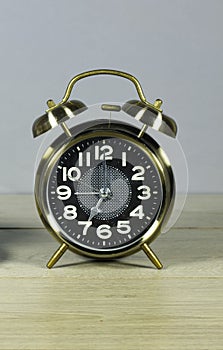 Alarm o`clock showing 7 o`clock on wood table