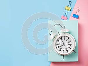 Alarm with supplies on color block background. Pastel minimalism