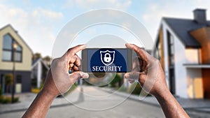 Alarm system. African-American man using phone, closeup