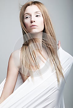 Alarmed gentle half-dressed girl in white clothes