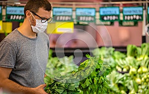 Alarmed male wears medical mask against coronavirus while grocery shopping in supermarket or store- health, safety and