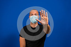 Alarming scared panicking man in hygienic mask gesturing stop, afraid of coronavirus infection, respiratory illnesses