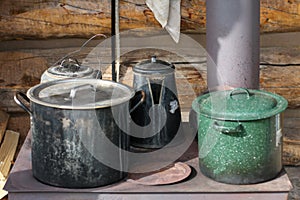 Alaska. Close up of pots and pans in an old iron cooking stove placed in the outside of a cabin.