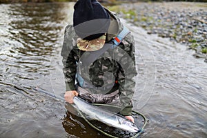 Alaska fly fisherman holding steelhead