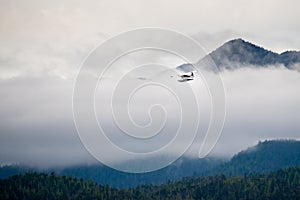 Alaskan Float Plane Flying Through Clouds
