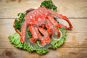 Alaskan King Crab Cooked steam or Boiled seafood and lettuce salad vegetable with wooden background - red crab hokkaido