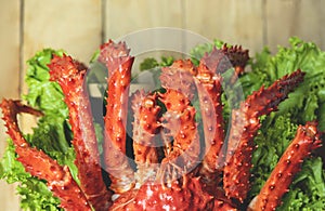 Alaskan King Crab Cooked steam or Boiled seafood and lettuce salad vegetable wooden dining table background , top view -  red crab