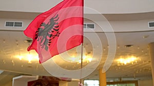 The Albanian flag sways with pride indoors