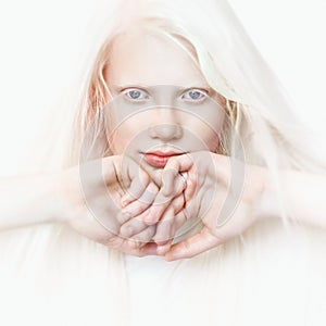 Albino girl with white pure skin, blue eyes and white hair. Photo face on a light background. Portrait of the head. Blonde girl