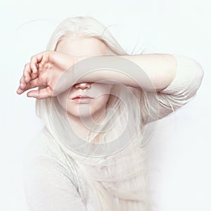 Albino girl with white pure skin, natural lips and white hair. Photo face on a light background. Portrait of the head. Blonde girl