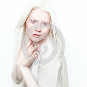 Albino woman with white pure skin and white hair. Photo face on a light background. Portrait of the head. Blonde girl photo