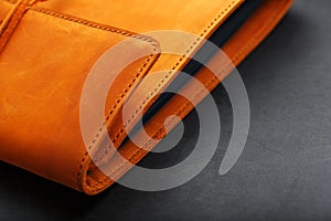The album cover is made of brown genuine leather, handmade on a black background. Elements of a leather product close-up