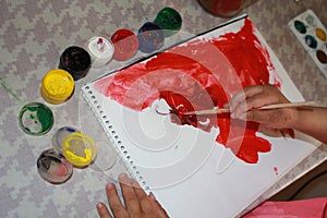 Album sheet. Paints. Watercolor. Hands of the child, 4 yearsold, photo. Red color on paper. Red paint on the album. Open colors. C