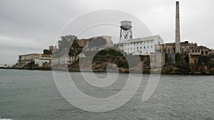 Alcatraz island in San Francisco Bay, California USA. Federal prison for gangsters on rock, foggy weather. Historic jail, cliff in
