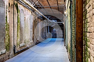 Alcatraz Prison old hallway inside the barracks apartment with rusty walls, ceiling grills and pipes