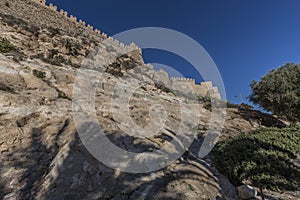 Alcazaba wall on a rocky hill from a lower perspective