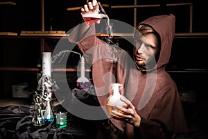 Alchemist in chemical laboratory prepares magical liquids