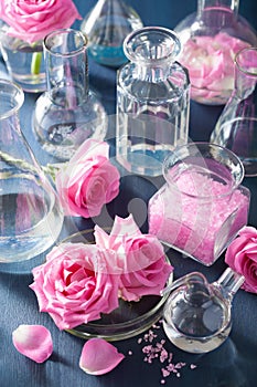 Alchemy and aromatherapy with rose flowers and chemical flasks