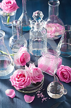 Alchemy and aromatherapy with rose flowers and chemical flasks