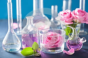 alchemy and aromatherapy set with rose flowers and chemical flasks