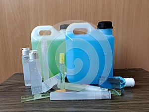 Alcohol-based type of hand sanitizer gel in many types of packaging, syringes on wooden background