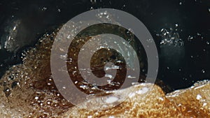 Alcohol cider foaming vessel closeup. Fizzy intoxicant drink splashing glass