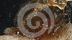 Alcohol cider foaming vessel closeup. Fizzy intoxicant drink splashing glass