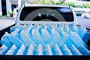 Alcohol for cleaning and sanitizing is contained in gallons on pick-up truck. Many gallon alcohol gel for sanitizing Coronavirus