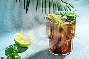 Alcohol cocktail cuba libre with rum, cola, mint and lime in the glass a light background, cookbook recipe top view