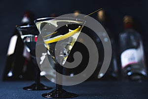 Alcohol cocktail with splash.Dry martini with black olives.Vermouth cocktail inside martini glass over dark background.Martini gla