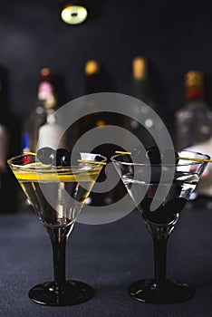 Alcohol cocktail with splash.Dry martini with black olives.Vermouth cocktail inside martini glass over dark background.Martini gla