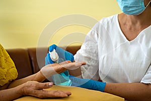 Alcohol disinfection of hands in  hospital with daughter taking care with protective face mask.  Health care and medicine concept
